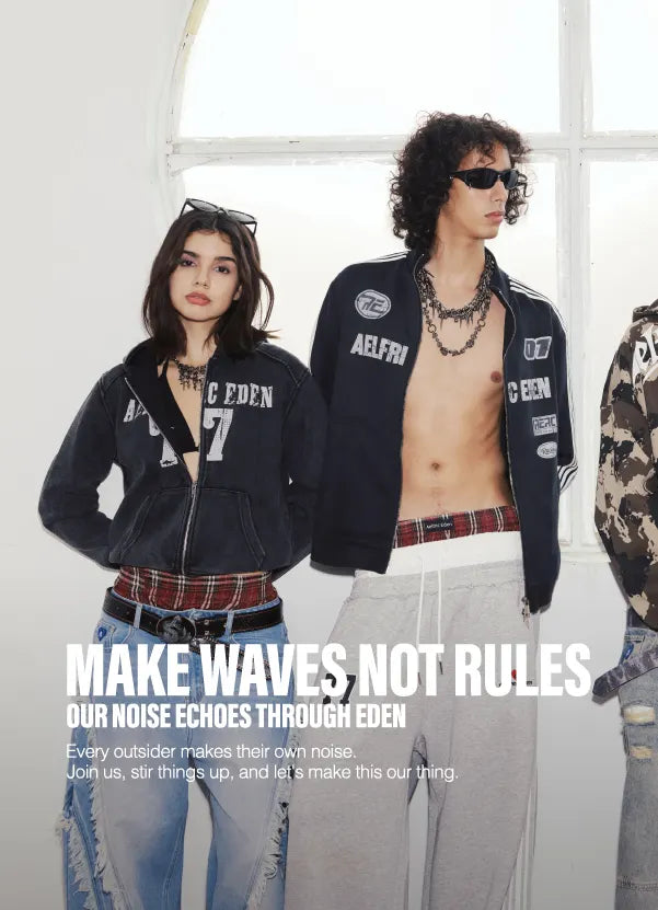 A rock band performs live in a bright white studio with arched windows. The lead singer wears sunglasses and a black-and-white jacket while holding a microphone, with a bassist, guitar player, and keyboardist behind him. 
"MAKE WAVES NOT RULES "THEME.